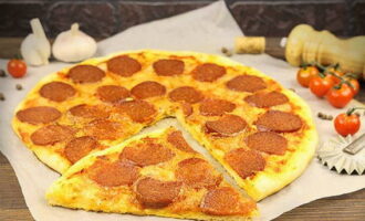 Готовую пиццу разрезаем на кусочки одинакового размера и наслаждаемся. 