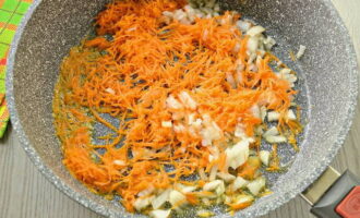Лук и морковь очистите и помойте. Лук нарежьте кубиками, морковь натрите на мелкой терке. Обжарьте овощи на растительном масле до мягкости.