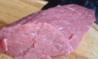 Ростбиф из говядины легко готовится в домашних условиях по классическому рецепту. Только свежее, незамороженное мясо подходит для ростбифа. Включите духовку и прогрейте ее до 250 градусов. Мясо помойте, обсушите и срежьте прожилки.