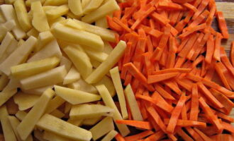 Оставшуюся морковь очищаем, промываем и нарезаем. То же самое проделываем с картофелем и отправляем его в кипящий бульон. Через 10 минут добавляем к картофелю морковь.