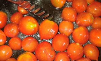 Разогреваем сковороду с растительным маслом. Опускаем сюда заранее промытые помидоры. Обжариваем их около 7-10 минут, аккуратно перемешивая.