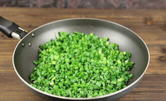 Измельчаем зеленый лук и томим его в сковороде со сливочным маслом около 5 минут.