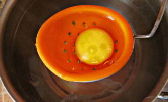 В кипящую воду добавляем соль и столовый уксус, уменьшаем огонь до минимального и осторожно вливаем яйцо в центр кастрюли.