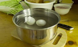 Салат с курицей готовится очень просто. Яйца сварите вкрутую в подсоленной воде. Затем очистите их, отделите белок от желтка. Белок в рецепте не потребуется, а желток нужен для соуса.