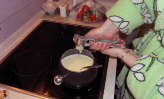 Затем всыпьте сыр и растворите его, интенсивно помешивая. Через 5 минут добавьте крахмал, продолжайте варить, соус должен стать однородным и тягучим. Добавьте специи и выдавите через пресс оставшийся чеснок.