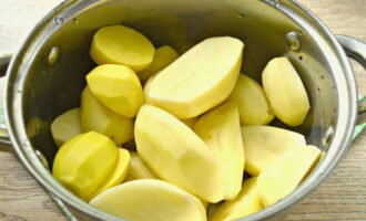 Как приготовить картофельное пюре с молоком? Картофель помойте, очистите от кожуры, порежьте на части и сложите в кастрюлю.