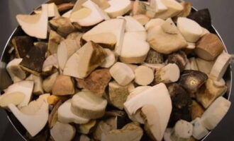 Чистые грибы порезать на половинки или средние кусочки и поместить их в большую кастрюлю.