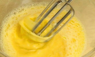 Яйца взбиваются с сахаром и солью, чтобы получилась пышная масса. К яичной смеси добавляют творог и манку.