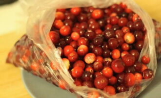 Для начала перебираем ягоды клюквы, убираем испорченные плоды и хорошо промываем её под проточной водой. Затем откидываем её на дуршлаг и оставляем, пока не стечёт вся лишняя жидкость.