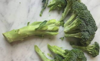 Как быстро и вкусно приготовить свежую брокколи на сковороде? Вилок брокколи ножом разделите на небольшие соцветия и толстые основания стеблей удалите. Затем соцветия на 10 минут залейте холодной водой.