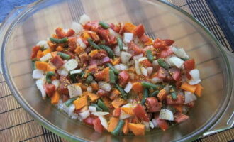 Лук, морковь, болгарский перец, фасоль и помидоры нарезаем кубиками и смешиваем. Выкладываем овощи сверху на рис, добавляем немного соли, универсальной приправы и чёрного молотого перца.