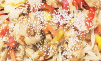 Приготовленную лапшу с курицей переложите в порционные тарелки, посыпьте семенами кунжута и можете подать к столу.