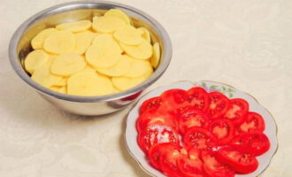 Картофель и помидоры нарежьте тонкими кружочками.