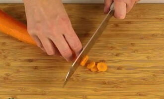Очищаем морковь (срезаем ножом верхний слой) и хорошенько промываем ее. Нарезаем корнеплоды кружочками.