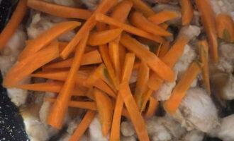 Когда в сковородке выкипит половина соуса, переложите в нее морковную соломку, смешайте с курицей и продолжите тушение также под прикрытой крышкой.