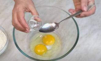 В миску разбиваем яйца. Добавляем соль и водку, взбалтываем вилкой. Порциями всыпаем муку и постепенно замешиваем плотное эластичное тесто. 