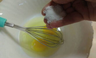 В небольшую по размеру миску вбиваем 2 яйца и добавляем к ним одну щепотку соли.