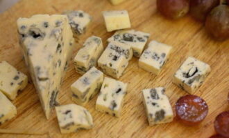 Канапе на шпажках на праздничный стол приготовить очень просто. Сыр с голубой плесенью нарезаем равными по размеру кубиками. По желанию, сыр можно заменить любым другим видом по вашему вкусу.