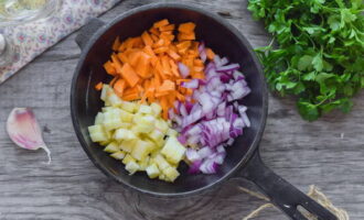 Лук, морковь и кабачок нарежьте кубиками. В сковороду влейте масло виноградных косточек и обжарьте на нем овощи в течение 2-3 минут.