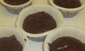 Получившееся тесто раскладывают по специальным формочкам, сверху посыпают шоколадными каплями. 