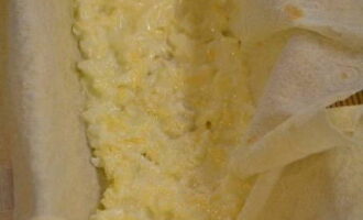 Форму для запекания устилаем лавашом таким образом, чтобы края свисали – щедро промазываем растопленным сливочным маслом, а в центр выкладываем часть сырной начинки и разравниваем. 
