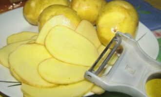 При помощи овощечистки нарежьте картофель тонкими слайсами. Можно нарезать и с помощью ножа.