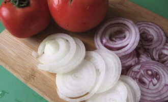 Два вида очищенных луковиц нарезают тонкими полукольцами или кольцами, томаты - кубиком.