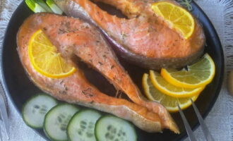 Запекайте рыбу в духовке 25 минут. Затем аккуратно снимите фольгу и подавайте стейки из семги с дольками лимона и свежей зеленью.