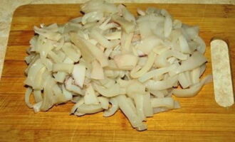 Тушки кальмаров промываем, варим после кипения 1-2 минуты и нарезаем тонкой соломкой.
