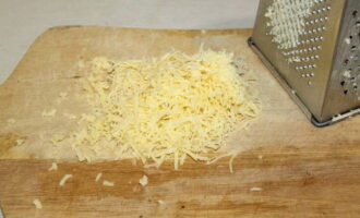 Натираем на мелкой терке сыр (полутвердый сорт) прямо в тарелку с плоским дном. 