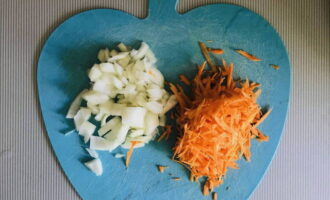 Очищаем лук с морковью, а после мелко разделываем их. Морковь рекомендуем натереть на крупной терке.