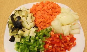 Сначала подготовим овощи. Баклажан, перцы, морковь и лук нарезаем мелкими кубиками.