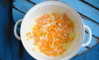 Для начала тщательно промываем красную чечевицу под проточной водой. Репчатый лук с морковью очищаем и мелко нарезаем. Очищенный и промытый картофель нарезаем небольшими кубиками. В кастрюле разогреваем растительное масло и обжариваем на нём лук до золотистого цвета. Далее добавляем морковь, картофель, перемешиваем и жарим ещё пару минут. Затем отправляем к овощам измельченный зубчик чеснока.