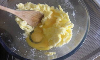 В полученную массу добавляем целое яйцо и два желтка, лимонную цедру с половины фрукта, ванилин и разрыхлитель.