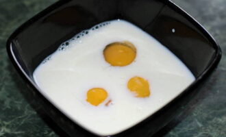 В глубокую миску вбиваем 3 яйца и заливаем их молоком. Приправляем ингредиенты солью, сахаром и ванилином. 