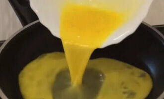 В сковороде разогреваем две столовых ложки растительного масла и выливаем яичную массу, даем немного времени, чтобы яйцо схватилось. 