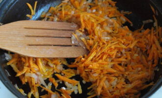 Разогреваем сковороду на плите вместе с растительным маслом. Выкладываем в емкость лук и морковь. Пассеруем ингредиенты с помощью лопатки.