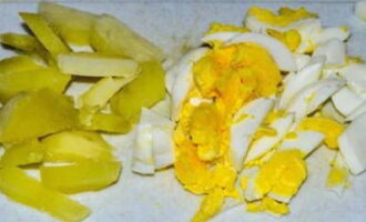 Заранее отвариваем картошку с яйцом. Очищаем продукты и также нарезаем кусочками поменьше.