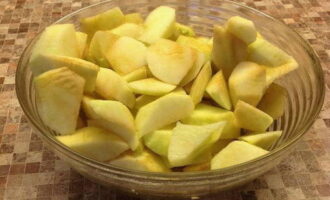 Яблоки для крамбла хорошо промойте, очистите от кожуры и нарежьте средними кусочками, удалив семенные коробочки. Чтобы яблочная нарезка не потемнела, полейте ее соком половинки лимона и перемешайте.