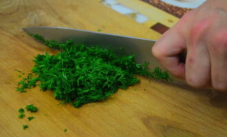 Промываем зелень, которую вы хотели бы добавить в тесто для хачапури. Избавляемся от лишней влаги, встряхивая пучок. Мелко нарезаем ингредиент и добавляем в тесто.