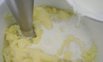 Молоко кипятим и заливаем им картофель. Также добавляем немного оставшейся от варки воды и взбиваем всё до получения нужной консистенции. При необходимости подливаем туда воду и добавляем соль.