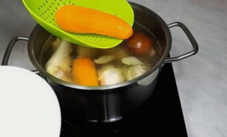 Спустя полчаса достаём из бульона морковь и перекладываем её на тарелку. За 30 минут до приготовления курицы, добавляем в бульон лавровый лист и соль по вкусу. 