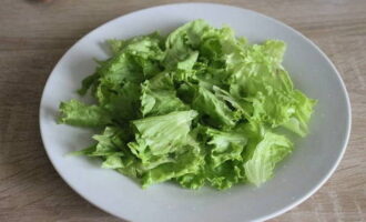 Как приготовить вкусный салат с форелью? Листья салата промываем, обсушиваем, рвем руками на части и выкладываем на тарелку.