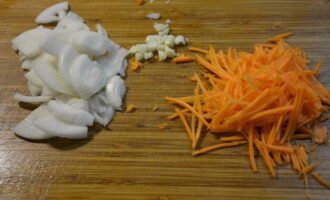 Луковицу нарезаем небольшими кусочками, морковку натираем на терке, а чеснок пропускаем через пресс.