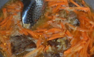 Влейте в казан кипяток, добавьте соль, головки чеснока и половину зиры. Варите зирвак пока морковь не станет мягкой. После этого извлеките из казана чеснок и отложите его в сторону.