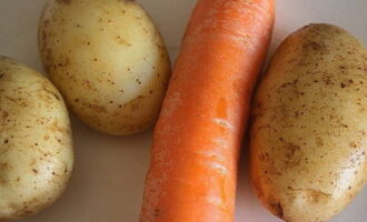 Картофель и морковь помойте, сварите в мундире. Готовые овощи очистите и натрите на терке по отдельности.
