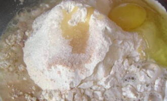 Замешиваем тесто для пирожков. Для этого в отдельную посуду насыпаем просеянную муку, добавляем к ней нужное количество соли с сахаром, сухих дрожжей, разбиваем одно яйцо и наливаем теплую воду с растительным маслом. Руками замешиваем тесто до однородного состояния, и чтобы получилось эластичным и мягким. Тесто прикрываем салфеткой и ставим на 2 часа в теплое место.