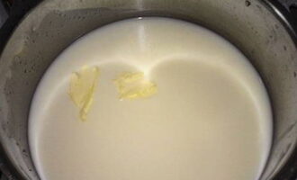 Затем влейте молоко и добавьте сливочное масло. Поставьте кастрюлю на плиту.