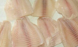 Филе рыбы (в рецепте тилапия) помойте холодной водой и салфеткой удалите всю влагу и мелкие косточки.