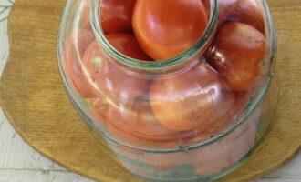 Свободно укладываем томаты в банку: стараемся более мелкие плоды размещать поверх крупных. Встряхиваем тару, чтобы помидоры плотно прилегали друг к другу.